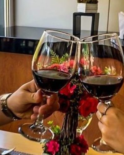 Pareja brindando con vino del Maule en EcoHotel Talca durante San Valentín